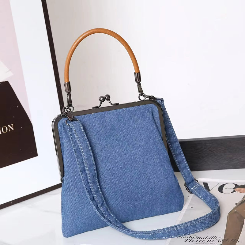 Bolso de mujer en denim azul con cierre metálico y asa redondeada marrón